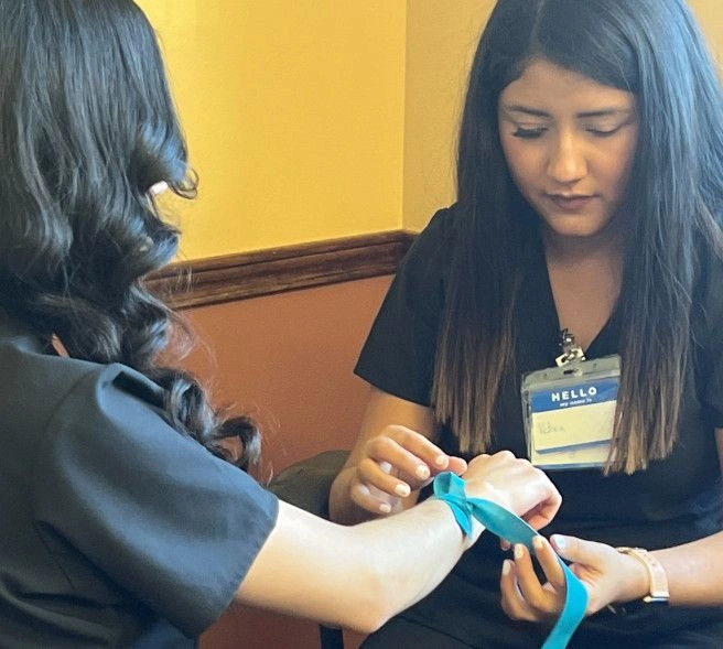 student applying a tourniquet  student applying a tourniquet